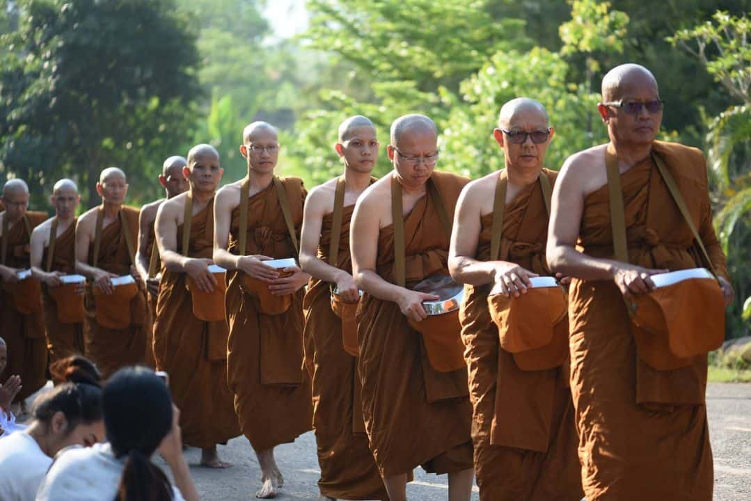 พระบวชใหม่เรียงแถวออกรับบิณฑบาต